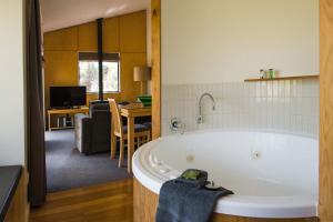 a bath room with a tub and a sink at Cradle Mountain Wilderness Village in Cradle Mountain