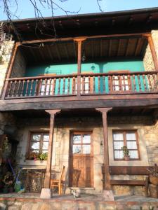 a house with a balcony and a wooden door at Casa de Aldea La Ablanera in Cangas de Onís