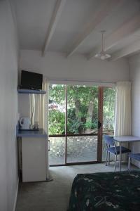 a bedroom with a bed and a table and a window at Martinborough Motel in Martinborough 