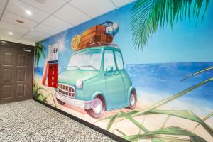 a room with a mural of a car with luggage at The Young Hotel in Zhongli