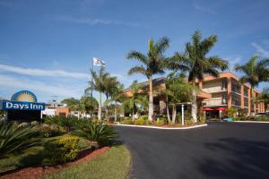 eine Straße vor einem Gebäude mit Palmen in der Unterkunft Days Inn by Wyndham Sarasota Bay in Sarasota