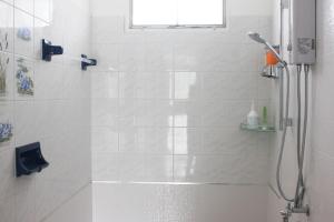 uma casa de banho branca com um chuveiro e uma janela em HOME@HOSTEL KANCHANABURI em Kanchanaburi