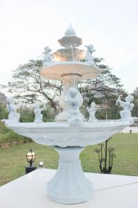 una gran fuente blanca sentada sobre una mesa en HOME@HOSTEL KANCHANABURI, en Kanchanaburi