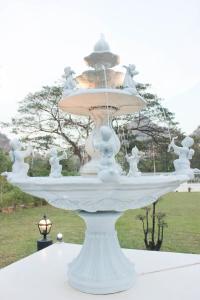 a large white fountain sitting on top of a table at HOME@HOSTEL KANCHANABURI in Kanchanaburi