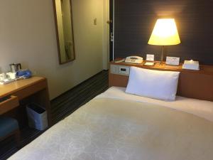 千岁千岁第一酒店的一间带床、书桌和灯的酒店房间 更多25张照片