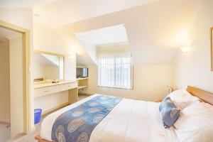 Un dormitorio con una cama grande y una ventana. en Queechy Motel, en St Helens