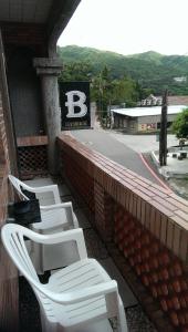 a row of white chairs sitting on a balcony at Jiufen B&B Uncle Xie's in Jiufen +22 photos