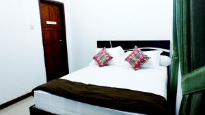 a bedroom with a white bed with four pillows at City Stay Homestay Jogja in Yogyakarta