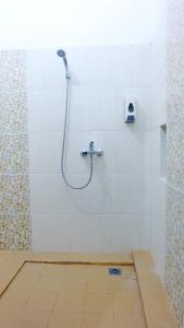 a shower in a bathroom with a tile floor at City Stay Homestay Jogja in Yogyakarta