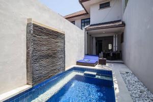 a swimming pool in the side of a house at Kuta Regency B10 One Bedroom Villa in Kuta