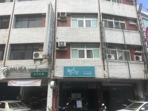 un edificio alto con un cartel delante en Captain Not At Home, en Hualien City