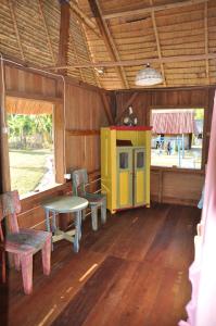 una habitación con mesa y sillas en una cabaña en 4 Pohon - Les 4 Arbres en Pandang