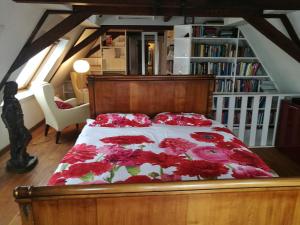 een slaapkamer met een bed met rode bloemen erop bij The Dutch Buoy in Monnickendam