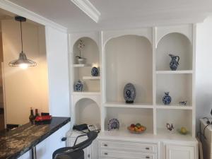 kuchnia z białymi półkami z niebiesko-białymi wazami w obiekcie R&E apartment w mieście Torremolinos