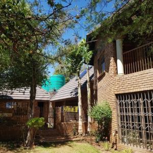 a brick house with a fence in front of it at Big Boma Guest House in Lydenburg