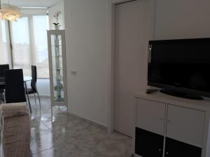 una sala de estar con TV de pantalla plana en un armario en Apartamento Exclusivo en la Playa 5, en Benidorm