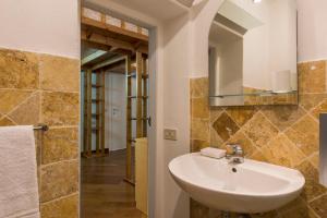 een badkamer met een wastafel en een spiegel bij Casa Raffaella in Pisa