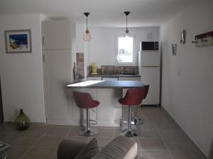 a kitchen with a counter and two stools in it at Oustau de Bigatié in Lambesc