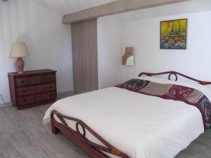 朗貝斯克的住宿－Oustau de Bigatié，卧室配有白色的床和木制梳妆台。