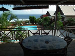 a table on a balcony with a view of the ocean at Le Cardinal des Grands Bleus in Saint-Leu