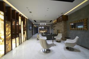 un salon avec des chaises blanches et une salle d'attente dans l'établissement Soyic Hotel, à Eskişehir