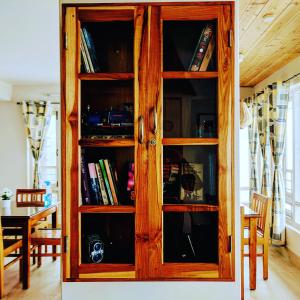 a wooden cabinet with glass doors in a room at Yuru Retreat Delo in Kalimpong
