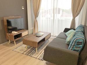 a living room with a couch and a tv at Seaview Apartment in Kuah