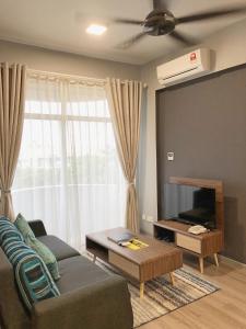uma sala de estar com um sofá e uma televisão de ecrã plano em Seaview Apartment em Kuah
