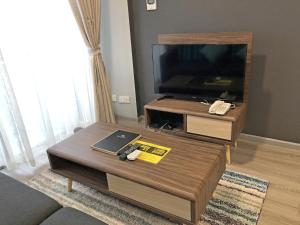 een woonkamer met een salontafel en een flatscreen-tv bij Seaview Apartment in Kuah