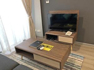 a living room with a coffee table and a flat screen tv at Seaview Apartment in Kuah