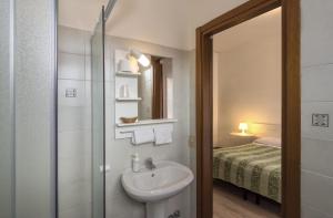 uma casa de banho com um lavatório e um chuveiro com uma cama em Hotel Cecile em Pisa mais 37 fotografias