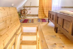 a room with a bed and two wooden stools at Dominic Boutique - Gardener's Cottage in Cloaşterf