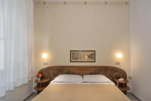 um quarto com uma cama com dois travesseiros em Hotel Cecile em Pisa