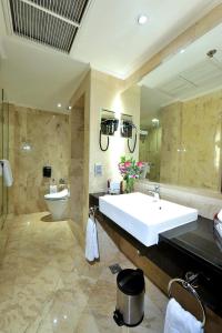 a bathroom with a large white sink and a toilet at Hotel Borobudur Jakarta in Jakarta