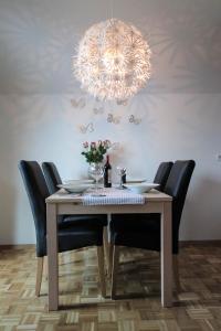 une table à manger avec des chaises et un lustre dans l'établissement Apartment Amazing View, à Bohinj