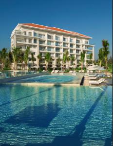 a hotel with a swimming pool in front of a building at Sunshine Apartment in 5* resort in Da Nang