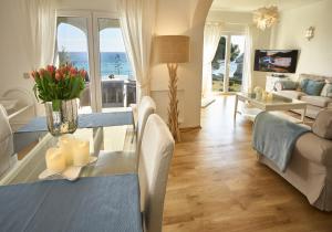 ein Wohnzimmer mit einem Tisch mit Blumen darauf in der Unterkunft E&M Beach House Aldeamento do Levante I in Armação de Pêra