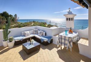 une terrasse avec une table et des chaises et l'océan dans l'établissement E&M Beach House Aldeamento do Levante I, à Armação de Pêra