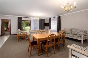 a living room with a wooden table and chairs at Milkwood Lodge in Hermanus