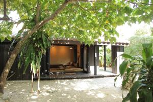 a house with a porch in the middle at Taketomijima Akaneya in Taketomi
