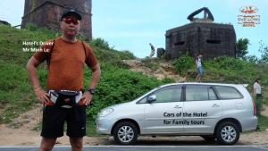 Um homem ao lado de um carro com um sinal. em Dai Long Hotel em Da Nang