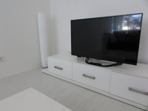 a flat screen tv sitting on top of a white cabinet at Beautiful city center Apartment with private parking in Martin