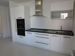 a white kitchen with a sink and a stove at Beautiful city center Apartment with private parking in Martin