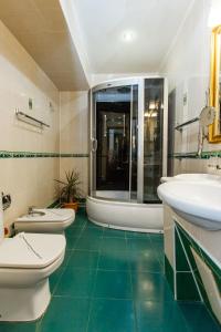 ein Badezimmer mit 2 Waschbecken und 2 WCs in der Unterkunft Grand Hotel Uyut in Krasnodar