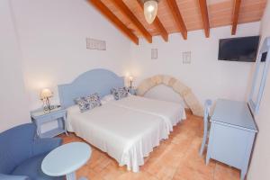 ein Schlafzimmer mit einem weißen Bett und einem Fernseher in der Unterkunft "Son Cleda" House Boutique, adults only in Sineu