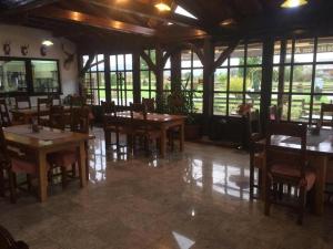 a restaurant with wooden tables and chairs and windows at Bed and Breakfast Albatros in Perušić