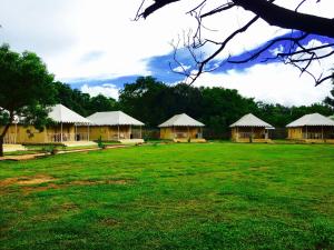 a group of yellow buildings with a green field at Rangiri Dambulla Resort in Dambulla