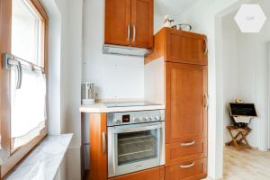 - une cuisine avec des placards en bois et un four dans l'établissement Apartment 81 qm, Messe/Exhibition Center, à Nuremberg