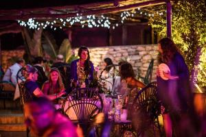 eine Gruppe von Menschen, die an einem Tisch mit Lichtern sitzen in der Unterkunft Les Jardins de Villa Maroc in Essaouira