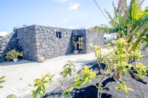 un edificio in pietra con piante di fronte di casa los veroles lanzarote a El Islote